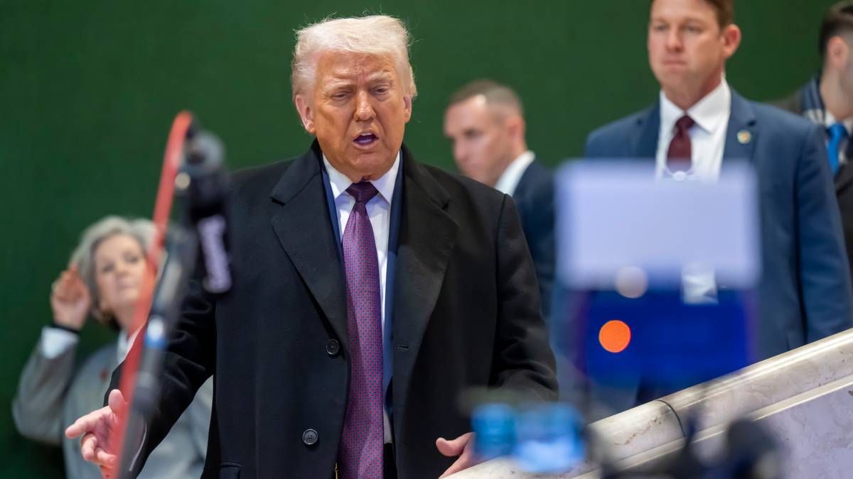 Donald Trump w garniturze i krawacie przemawia.