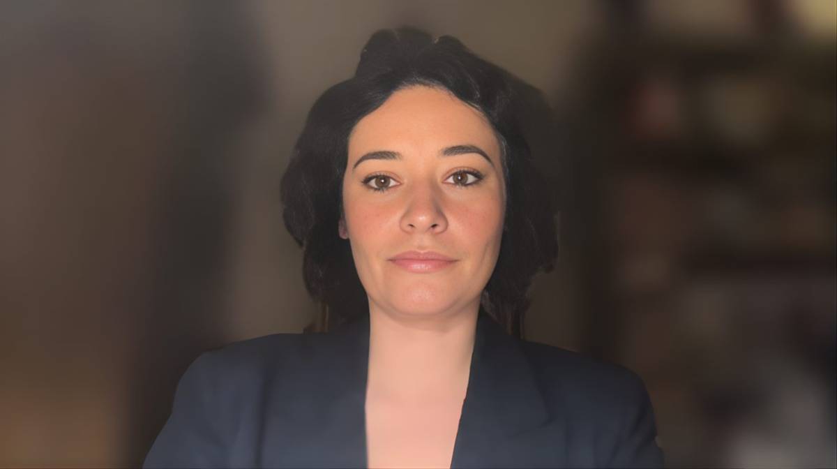 Kobieta w ciemnej marynarce patrzy prosto w obiektyw.