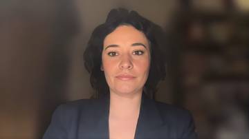 Kobieta w ciemnej marynarce patrzy prosto w obiektyw.